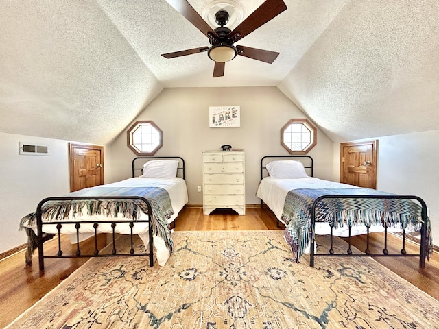 bedroom with vaulted ceiling, ceiling fan, and multiple windows