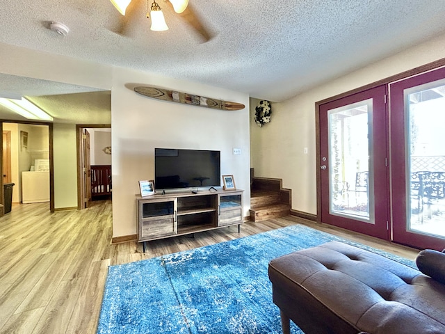 living room with ceiling fan, wood-type flooring, and a textured ceiling