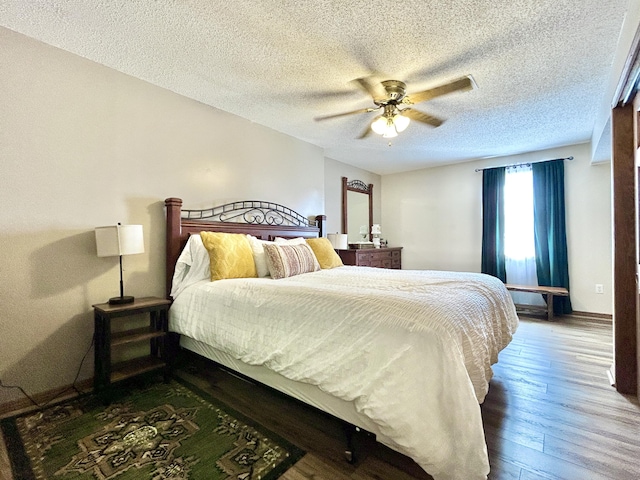 bedroom with ceiling fan, a textured ceiling, and dark hardwood / wood-style flooring