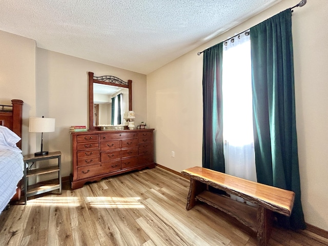 bedroom featuring light wood-type flooring and a textured ceiling