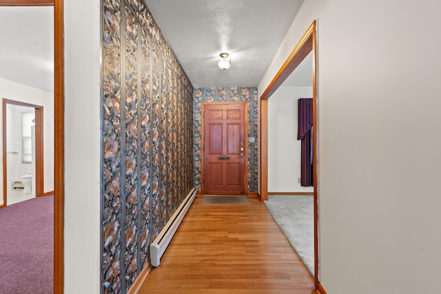 hall featuring light hardwood / wood-style flooring and a baseboard heating unit