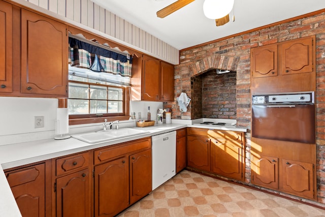 kitchen with white appliances, brick wall, ceiling fan, and sink