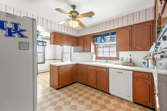 kitchen featuring white appliances, ceiling fan, kitchen peninsula, and sink