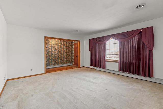 unfurnished room with a baseboard heating unit and light carpet