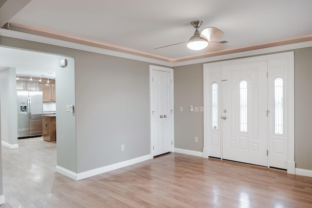 foyer with crown molding, ceiling fan, and light wood-type flooring