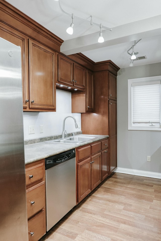 kitchen with stainless steel appliances, sink, and light wood-type flooring