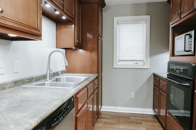 kitchen with stainless steel appliances, sink, and light hardwood / wood-style flooring