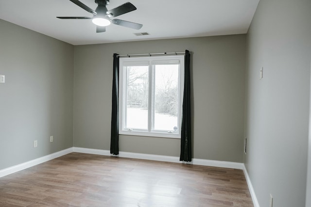 empty room with ceiling fan and light hardwood / wood-style floors