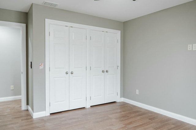 unfurnished bedroom with two closets and light hardwood / wood-style flooring