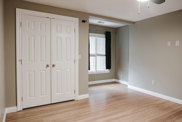 unfurnished bedroom with light hardwood / wood-style flooring, a closet, and ceiling fan