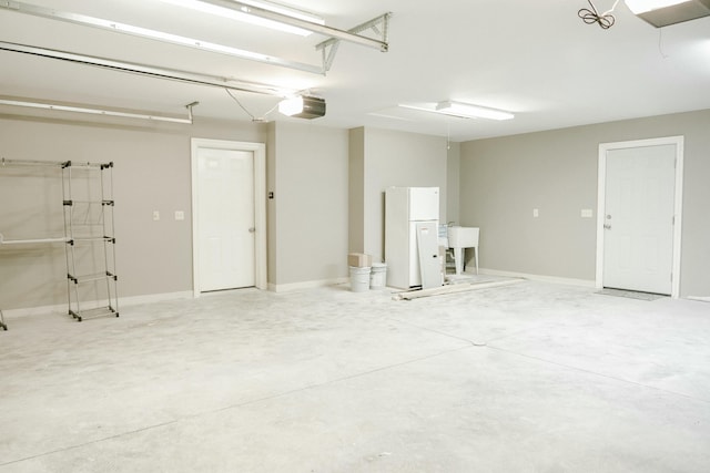 garage with a garage door opener and white fridge