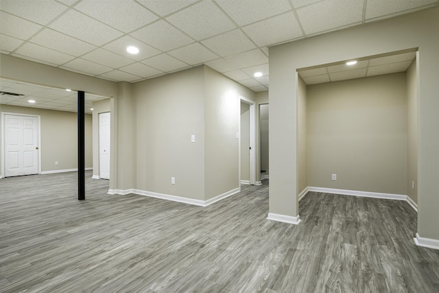 basement with hardwood / wood-style flooring and a paneled ceiling