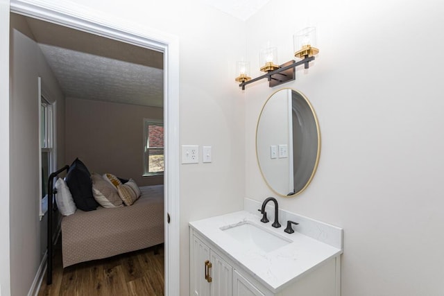 bathroom with vanity, a textured ceiling, and wood finished floors