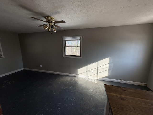 empty room with a textured ceiling, concrete flooring, and ceiling fan