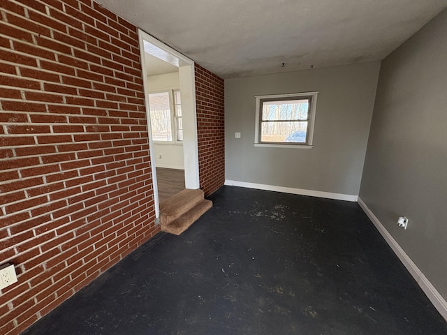 unfurnished room with brick wall