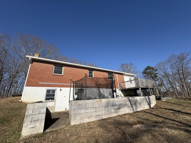 rear view of house with a yard and a wooden deck