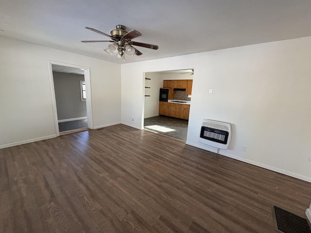 unfurnished living room with ceiling fan, dark hardwood / wood-style floors, and heating unit