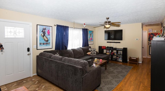 living room featuring a textured ceiling, dark hardwood / wood-style floors, and ceiling fan