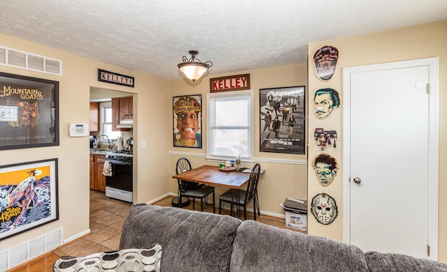 tiled dining room featuring sink and a textured ceiling