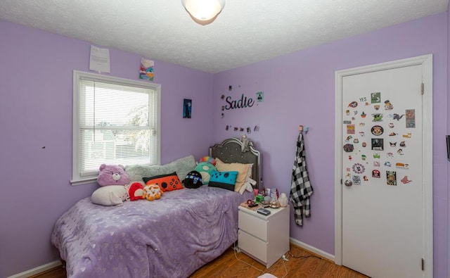 bedroom featuring light wood-type flooring and a textured ceiling