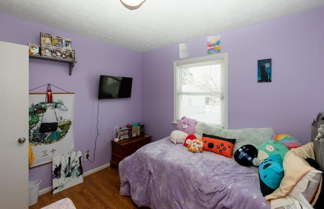 bedroom featuring wood-type flooring and a textured ceiling