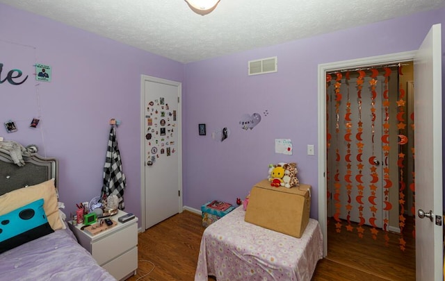 bedroom with a textured ceiling and hardwood / wood-style flooring