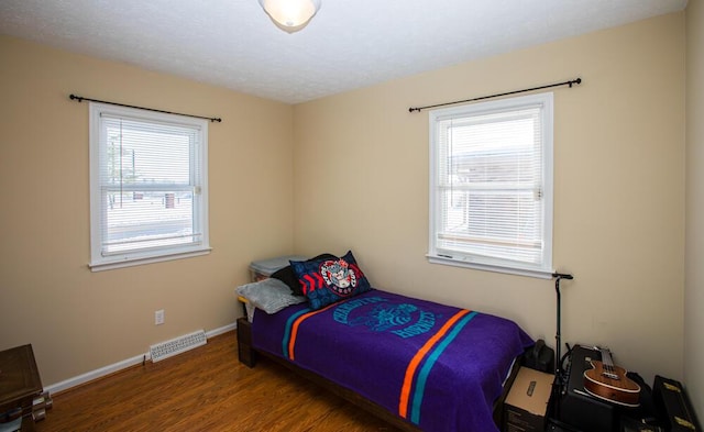 bedroom featuring dark wood-type flooring and multiple windows