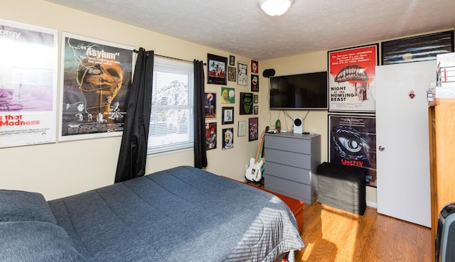 bedroom featuring wood-type flooring and a textured ceiling