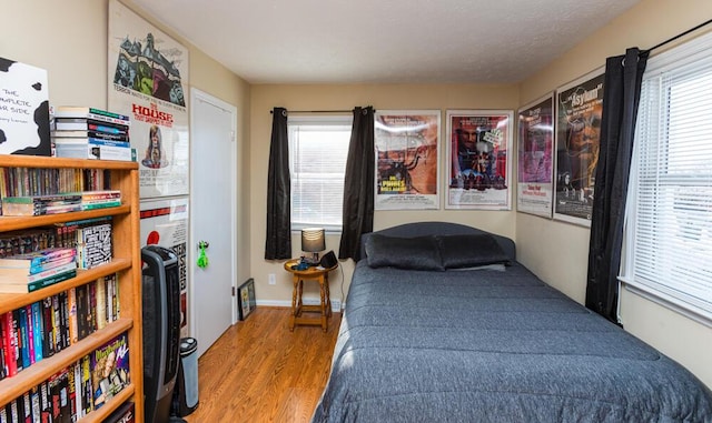 bedroom featuring a textured ceiling and light hardwood / wood-style flooring