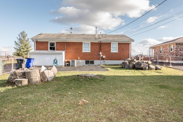 back of house with central air condition unit and a yard