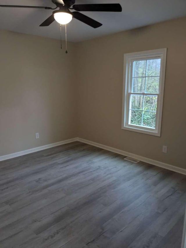 spare room with ceiling fan and dark hardwood / wood-style flooring