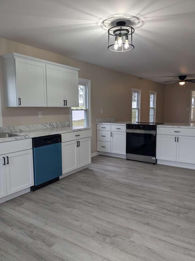 kitchen featuring white cabinetry, sink, stainless steel appliances, light hardwood / wood-style floors, and ceiling fan with notable chandelier