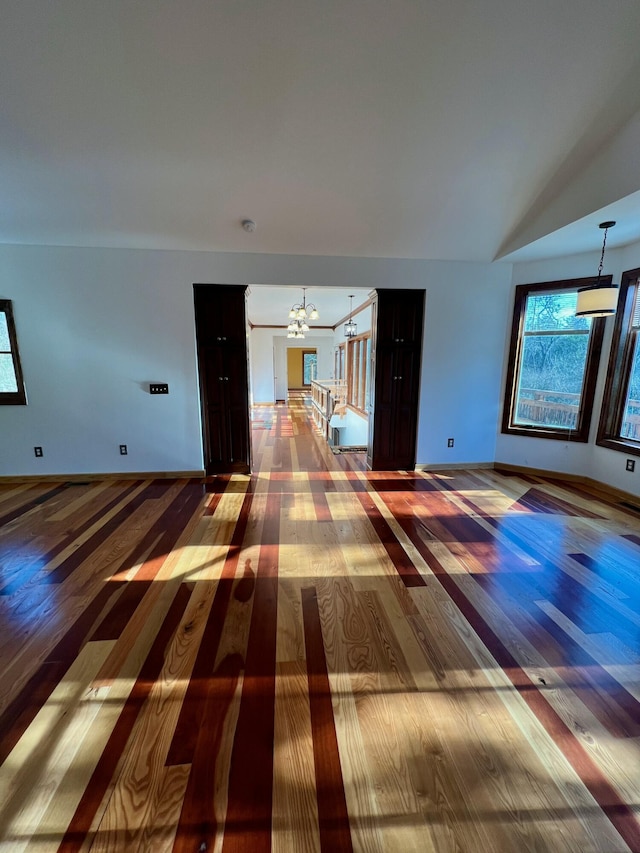 spare room featuring vaulted ceiling, a chandelier, and hardwood / wood-style floors