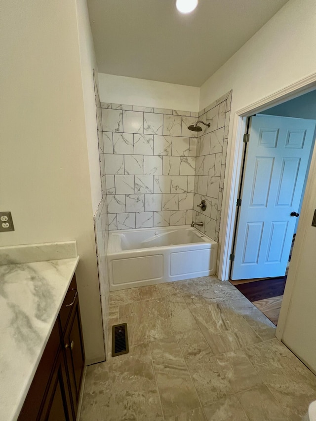 bathroom featuring vanity and tiled shower / bath