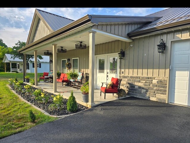 entrance to property with a yard, covered porch, and a garage