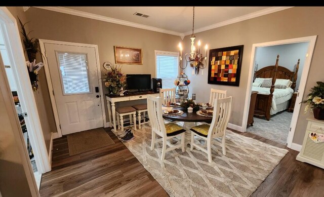 dining room featuring a notable chandelier, dark wood-type flooring, and crown molding