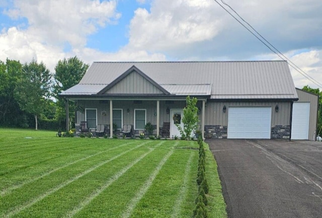 view of front of house featuring a front yard, covered porch, and a garage