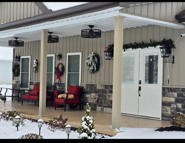 snow covered property entrance with a porch