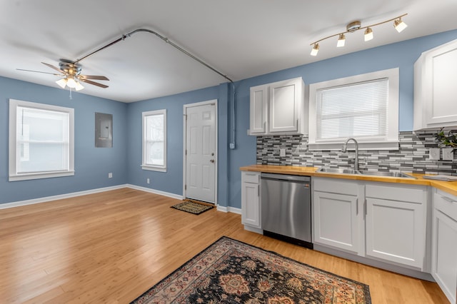 kitchen with sink, stainless steel dishwasher, butcher block countertops, backsplash, and white cabinets