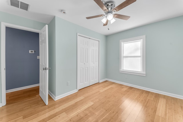 unfurnished bedroom featuring ceiling fan, a closet, and light hardwood / wood-style floors