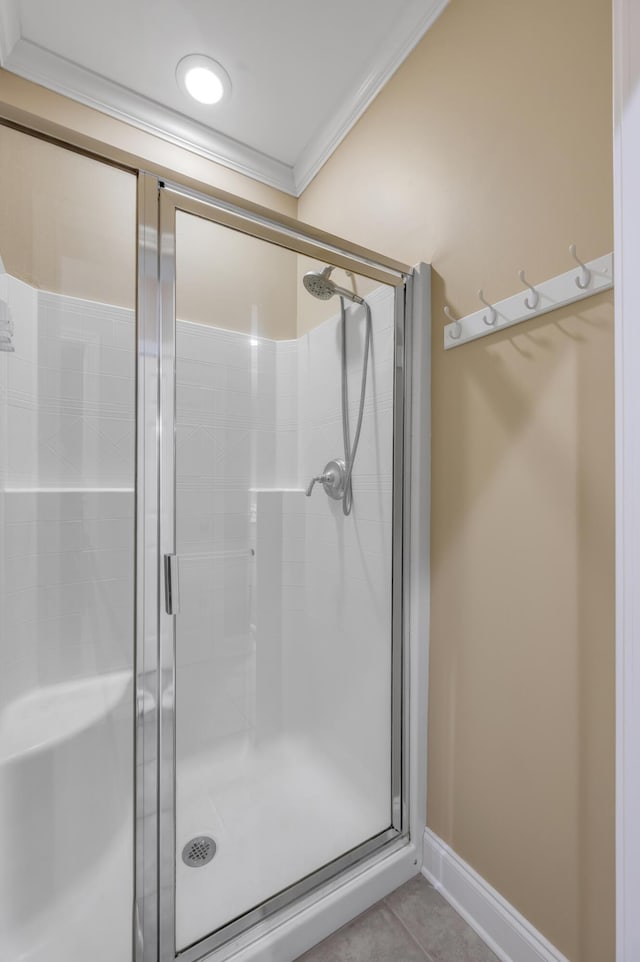 bathroom with tile patterned floors, walk in shower, and crown molding