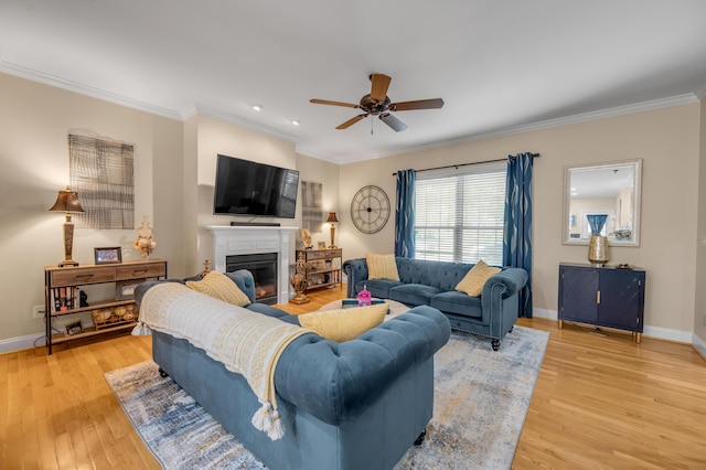 living room featuring light hardwood / wood-style floors, ceiling fan, and ornamental molding