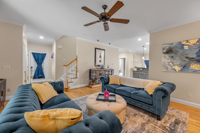 living room featuring ceiling fan, crown molding, and wood-type flooring