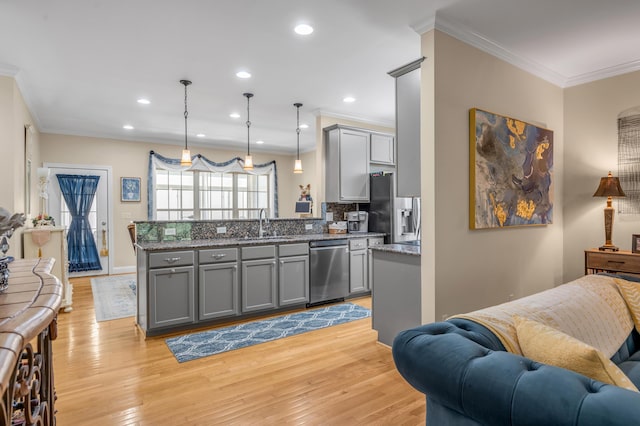 kitchen featuring appliances with stainless steel finishes, light wood-type flooring, hanging light fixtures, and gray cabinetry