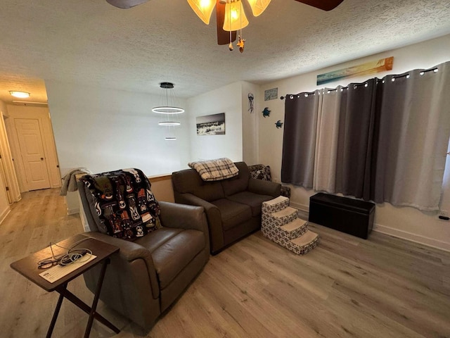 living room with ceiling fan, hardwood / wood-style floors, and a textured ceiling