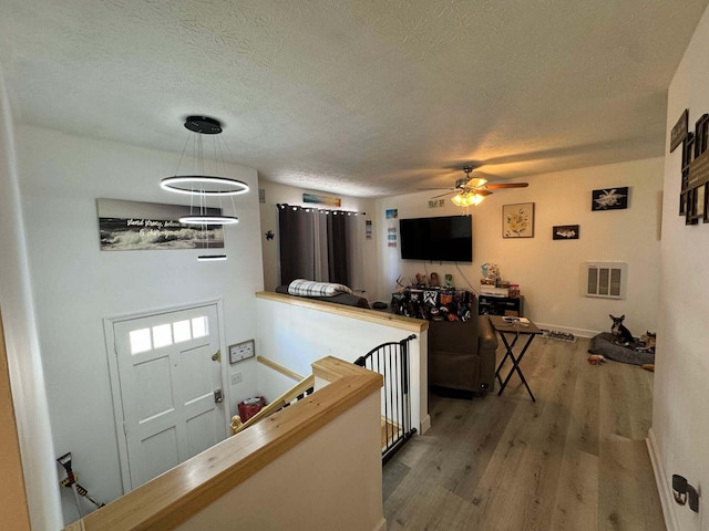 kitchen featuring a textured ceiling, ceiling fan, decorative light fixtures, and hardwood / wood-style flooring