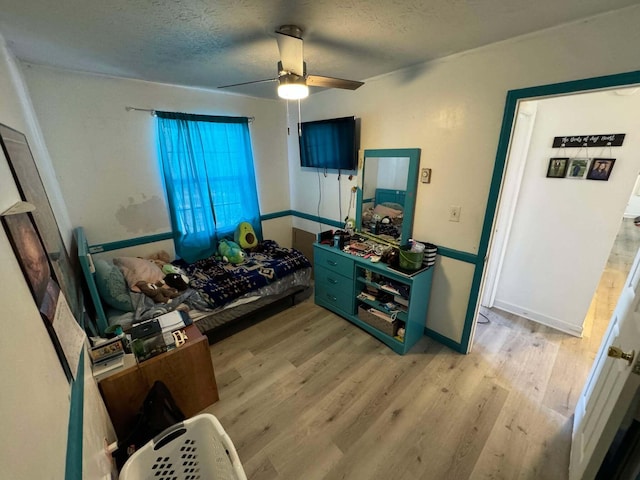 interior space featuring ceiling fan, a textured ceiling, and light hardwood / wood-style flooring