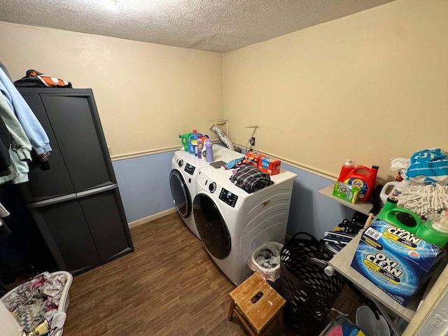 clothes washing area featuring dark wood-type flooring, washer and dryer, and a textured ceiling