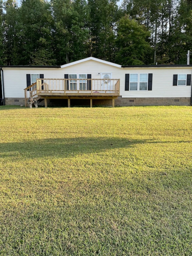 back of house with a deck and a lawn