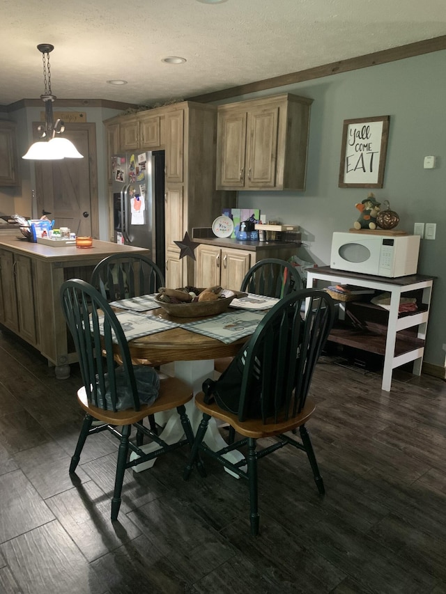 dining area with ornamental molding and dark hardwood / wood-style floors